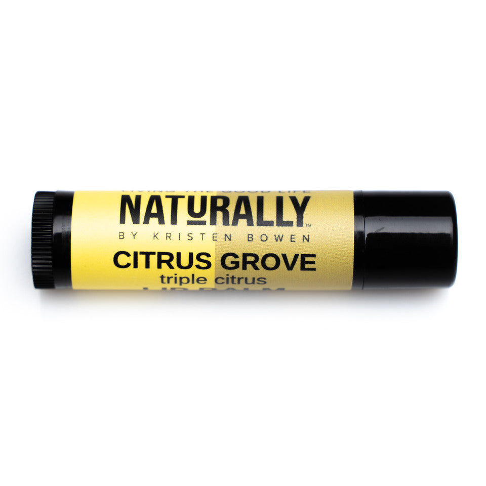 A brown lip balm tube with a yellow label. The label reads “Naturally by Kristin Bowen, Citrus Grove, Triple Citrus”.