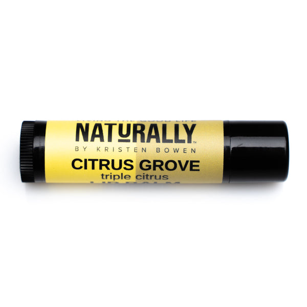 A brown lip balm tube with a yellow label. The label reads “Naturally by Kristin Bowen, Citrus Grove, Triple Citrus”. 